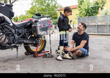 Heureux père et fils à côté d'une moto Banque D'Images