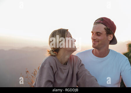 Happy young couple en randonnée ayant une pause au lever du soleil Banque D'Images