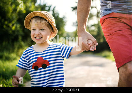 Portrait of laughing toddler marche sur main du père Banque D'Images