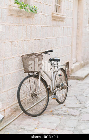 Old rusty vintage bicycle appuyé contre un mur de pierre, à l'extérieur Banque D'Images