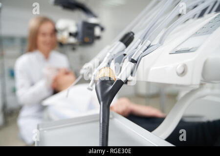 Close up de professionnel de soins dentaires de l'équipement et des outils. Clinique privée moderne avec de nouveaux outils et instruments. Dentiste examining patient à l'aide de microscope en clinique. Banque D'Images