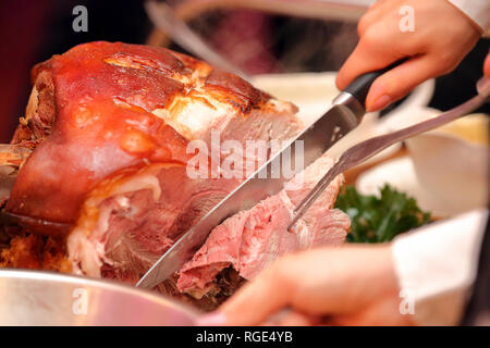 Serveur sert de viande rôtie et pommes de terre au four à la fête ou réception de mariage Banque D'Images