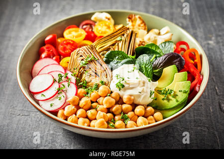 Bol Bouddha colorés avec une variété de légumes frais et sain, y compris les pois chiches, avocat, radis, poivrons, tomates, choux-fleurs et artichok Banque D'Images