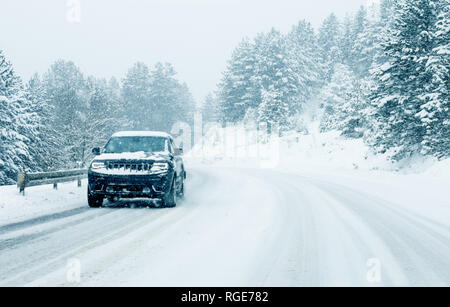 Les voitures de la circulation sur la route d'hiver dans la tempête de neige Banque D'Images