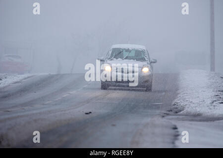 Flintshire, au nord du Pays de Galles, 29 janvier 2019. Météo France : de nombreux domaines, voir la neige tomber dans les jours à venir avec un domaine à Flintshire touchés par la chute de neige de l'ouest comme cette automobiliste a découvert la lutte contre les conditions de conduite difficiles passant sur Halkyn, Montagne © DGDImages AlamyLiveNews/Flintshire Banque D'Images