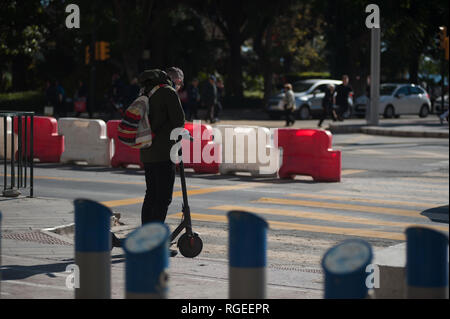 Un homme libre à l'aide d'un scooter électrique est vu vérifie son téléphone mobile comme il attend pour traverser le passage pour piétons. Le général espagnol demande Gestion du trafic à partir de maintenant un permis de conduire pour les scooters électriques et une assurance parmi d'autres mesures, selon un nouveau décret du gouvernement espagnol. Au cours des derniers mois a été passé plus d'accidents à l'aide de scooters électriques et un décès l'année dernière. Le gouvernement pense comme ceci pour réglementer l'utilisation de ce transport et améliorer la sécurité. Banque D'Images