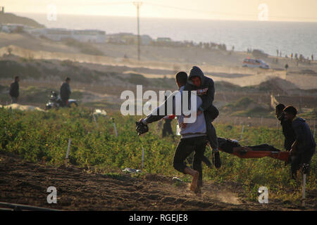 Gaza, la Palestine. 29 janvier, 2019. Les médecins palestiniens vu porter un manifestant blessé lors d'affrontements entre Palestiniens et forces israéliennes alors qu'ils protestaient contre sur le nord de la bande de Gaza. Credit : Ahmad Hasaballah SOPA/Images/ZUMA/Alamy Fil Live News Banque D'Images