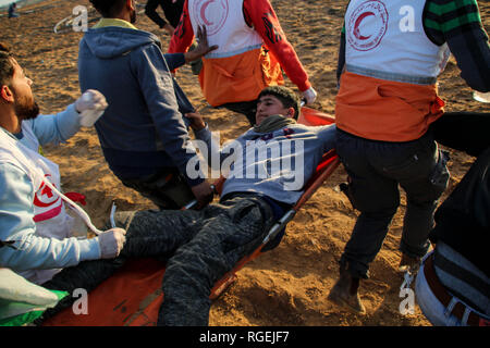 Gaza, la Palestine. 29 janvier, 2019. Les médecins palestiniens vu porter un manifestant blessé lors d'affrontements entre Palestiniens et forces israéliennes alors qu'ils protestaient contre sur le nord de la bande de Gaza. Credit : Ahmad Hasaballah SOPA/Images/ZUMA/Alamy Fil Live News Banque D'Images