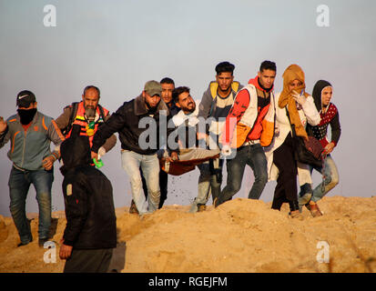 Gaza, la Palestine. 29 janvier, 2019. Les médecins palestiniens vu porter un manifestant blessé lors d'affrontements entre Palestiniens et forces israéliennes alors qu'ils protestaient contre sur le nord de la bande de Gaza. Credit : Ahmad Hasaballah SOPA/Images/ZUMA/Alamy Fil Live News Banque D'Images