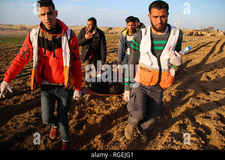 Gaza, la Palestine. 29 janvier, 2019. Les médecins palestiniens vu porter un manifestant blessé lors d'affrontements entre Palestiniens et forces israéliennes alors qu'ils protestaient contre sur le nord de la bande de Gaza. Credit : Ahmad Hasaballah SOPA/Images/ZUMA/Alamy Fil Live News Banque D'Images