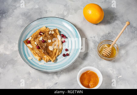 Crêpes traditionnelles de banane et fruits rouges sur fond de béton. Banque D'Images