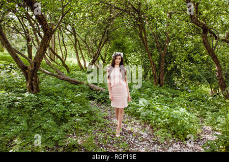 Jolie femme en robe rose à fleurs jardin à l'extérieur de marche Banque D'Images