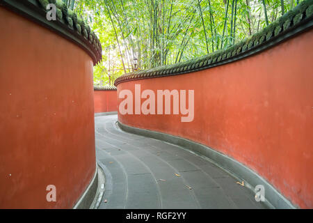 Passage de mur rouge en courbes, entouré de forêt de bambou appliqués colorés Chengdu Wuhou Temple de la Chine. Banque D'Images