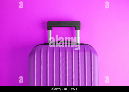 Valise sur fond violet creative travel concept minimal. Banque D'Images