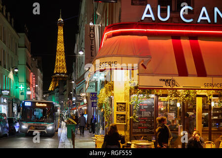 PARIS - 8 NOVEMBRE 2018 : Tour Eiffel illuminée la nuit et la rue avec le bus, les gens et restaurant typique de Paris, France Banque D'Images