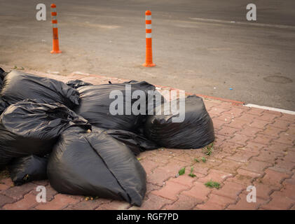 Pile de sacs à déchets noir bas sur la chaussée. Banque D'Images