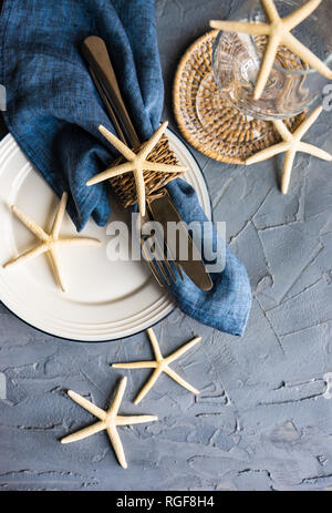 Table d'été blanc avec l'étoile de mer sur fond de béton with copy space Banque D'Images