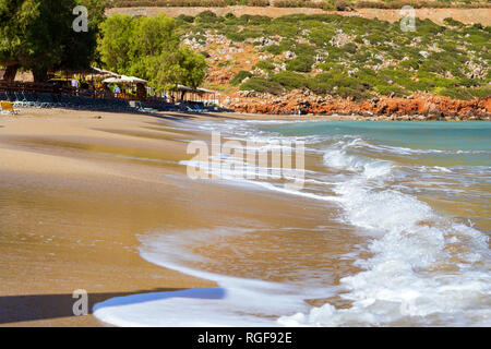 Surfez et vague de mousse des vagues sur une plage de sable. Sunny sandy Livadi Beach dans la baie de la mer de Bali village resort. Les vagues de la mer de sable de la plage déserte. Bali, Rethymno, Crète, Grèce Banque D'Images