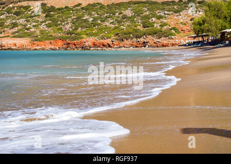 Surfez et vague de mousse des vagues sur une plage de sable. Sunny sandy Livadi Beach dans la baie de la mer de Bali village resort. Les vagues de la mer de sable de la plage déserte. Bali, Rethymno, Crète, Grèce Banque D'Images