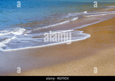 Surfez et vague de mousse des vagues sur une plage de sable. Sunny sandy Livadi Beach dans la baie de la mer de Bali village resort. Les vagues de la mer de sable de la plage déserte. Bali, Rethymno, Crète, Grèce Banque D'Images