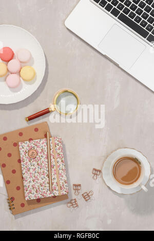 Espace de travail avec ordinateur portable, portable, lunettes, tasse de café et fleurs de lisianthus sur fond gris. Vue de dessus de table bureau féminin 24. Freelancer wor Banque D'Images