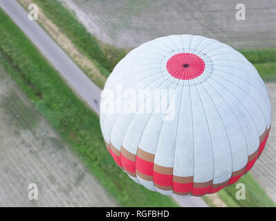 Ballon à air chaud blanc avec une bande rouge et or suspendu au-dessus du Feldmark de Basse-Saxe, vue sur le ballon d'en haut. Banque D'Images