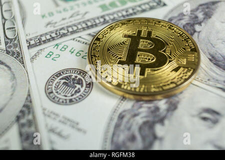 Bitcoin Gold sur cent dollars bills. Close-up, macro shot. Banque D'Images