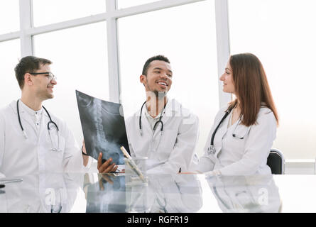 Collègues médecins discuter de x-ray, assis à la table de bureau Banque D'Images