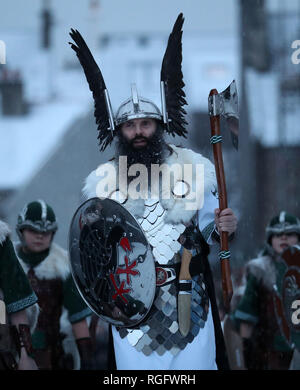 Guizer Jarl John Nicolson et son équipe mars à Lerwick, comme de la neige tombe sur l'Îles Shetland au cours de l'Up Helly Aa festival viking. Originaires dans les années 1880, le festival célèbre le patrimoine scandinave Shetland. Banque D'Images