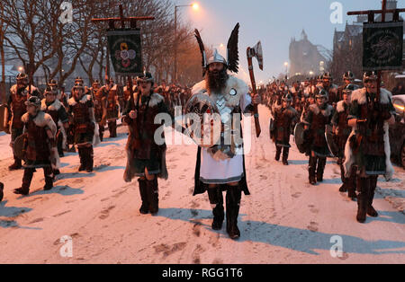 Guizer Jarl John Nicolson et son équipe mars à Lerwick, comme de la neige tombe sur l'Îles Shetland au cours de l'Up Helly Aa festival viking. Originaires dans les années 1880, le festival célèbre le patrimoine scandinave Shetland. Banque D'Images