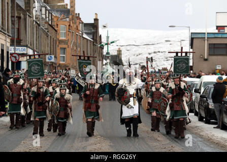 Guizer Jarl John Nicolson et son équipe mars à Lerwick, comme de la neige tombe sur l'Îles Shetland au cours de l'Up Helly Aa festival viking. Originaires dans les années 1880, le festival célèbre le patrimoine scandinave Shetland. Banque D'Images