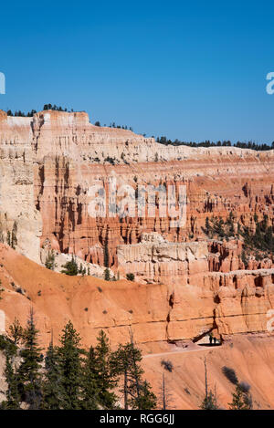 Bryce Canyon trail avec les randonneurs lointain en passant par rock arch sur ciel bleu ensoleillé jour au printemps Banque D'Images