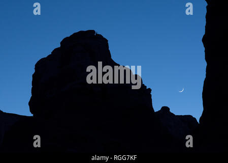 L'établissement croissant de lune au-dessus de la silhouette Rock Ridge de Goblin Valley State Park, Utah Banque D'Images