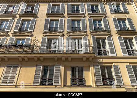 Volets en bois blanc et balcon en fer forgé sur un immeuble le long de la rue Saint-Dominique, Paris,France Banque D'Images