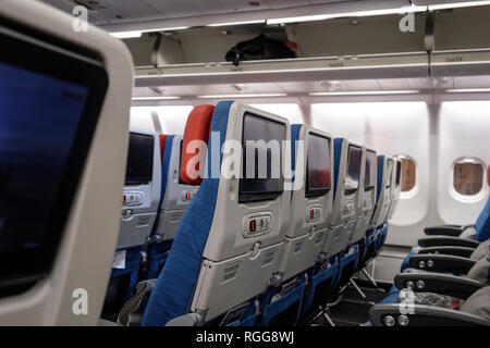 Des rangées de sièges vides à l'intérieur d'un avion commercial Banque D'Images