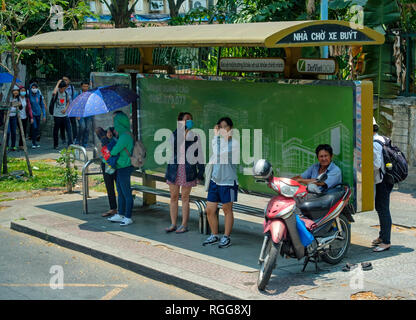 Les personnes en attente de transport public à un arrêt d'autobus à Ho Chi Minh City, Vietnam, Asie Banque D'Images