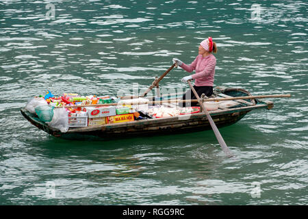 Femme vendant des produits à partir d'un bateau sur la baie d'Halong, Vietnam, Asie Banque D'Images