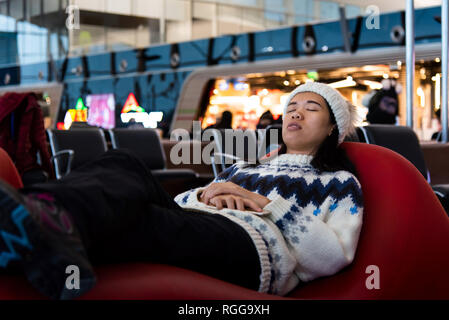 Prendre une sieste tandis que fille attendait à l'aéroport lounge Banque D'Images