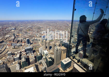 Les touristes en tenant sur la Corniche "selfies' de la plate-forme d'observation Skydeck sur haut de la Willis Tower (ex-Sears Tower). Chicago, Illinois, États-Unis Banque D'Images