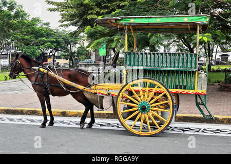 Cheval kalesa-calèche arrêté à Sto Tomas.Street-Plaza de Roma Square à l'entrée de la cathédrale lors de l'attente pour les passagers se rendant sur l'intr Banque D'Images