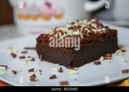 Les tranches en forme de triangle morceau de gâteau fondant au chocolat foncé topping chocolat blanc avec boucle sur fond isolé avec chemins de détourage. Boulangerie maison Banque D'Images