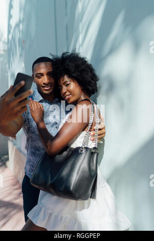 Smiling young couple embracing selfies et prendre une Banque D'Images