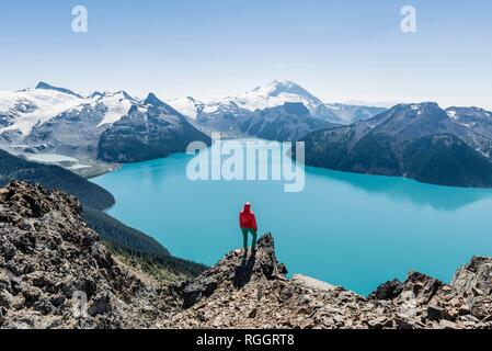 Vue depuis le sentier de randonnée Panorama Ridge, Randonneur sur un rocher, Garibaldi Lake, la Montagne de la garde et de la Tromperie, Pic Glacier Retour Banque D'Images