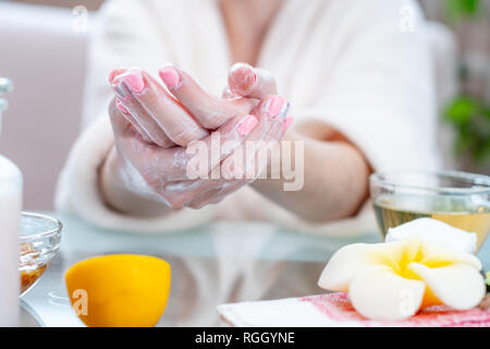 La femme l'application de la crème sur ses mains hydratant et nourrissant avec les cosmétiques naturels close-up. Concept d'hygiène et de soins pour la peau Banque D'Images