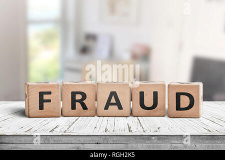 Signe de la fraude faite de blocs de bois blanc sur un bureau dans une salle lumineuse Banque D'Images