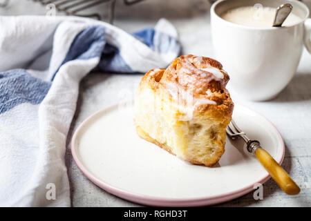 Accueil-cuit au four à la cannelle avec du sucre glace et une tasse de café Banque D'Images