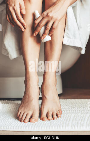 Les jambes des femmes. Jeune femme dans la salle de bain, caressant ses jambes. Banque D'Images