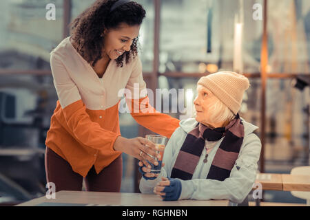 Heureux jeune femme portant un verre d'eau Banque D'Images