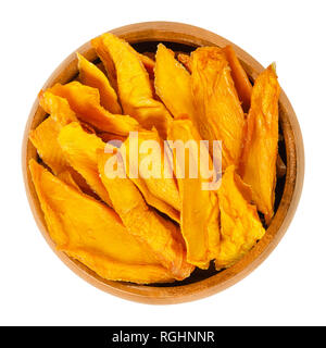 La mangue séchée dans bol en bois. Tranches de Mangues, déshydratées. Tropical fruit juteux en pierre jaune et orange. Mangifera. Banque D'Images