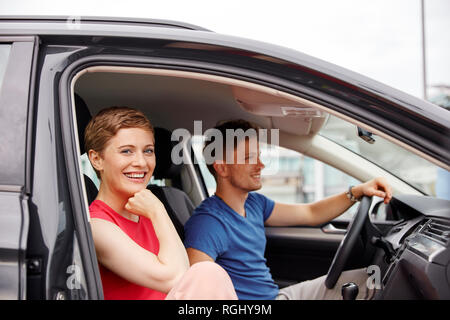 Happy young couple in a car Banque D'Images